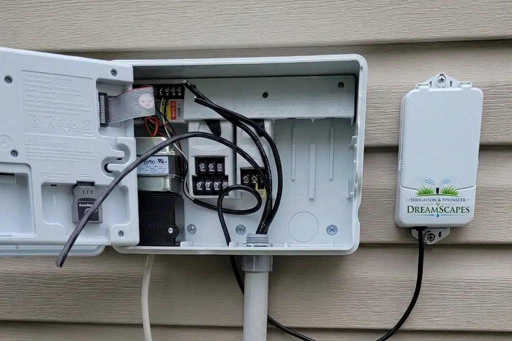 Open irrigation timer control box mounted on home exterior
